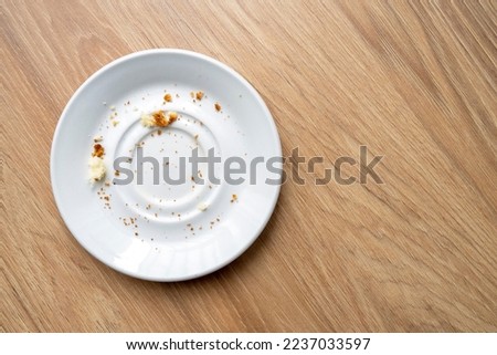 Brown cake crumbs on round white plate, top view