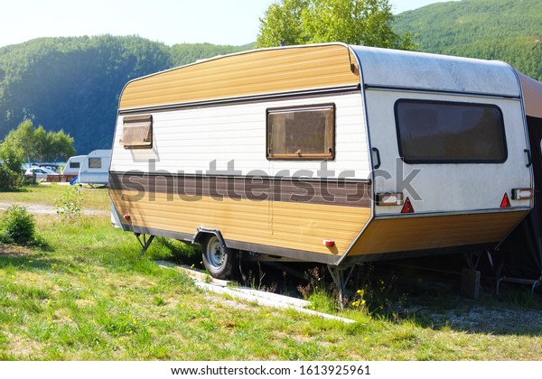 brown camping trailer on a\
background of mountain nature, the theme of leisure and\
travel\
