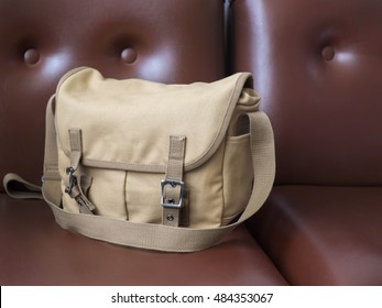 Brown Canvas Messenger Bag On Brown Leather Sofa