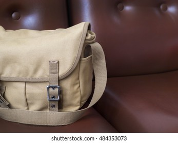 Brown Canvas Messenger Bag On Brown Leather Sofa