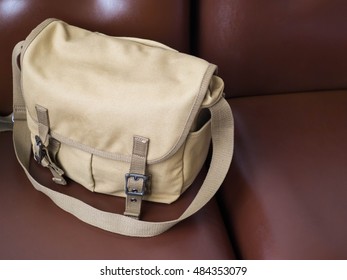 Brown Canvas Messenger Bag On Brown Leather Sofa