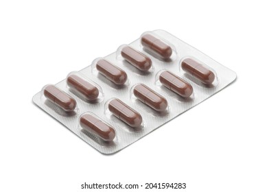 Brown capsules in aluminum blister pack isolated on white