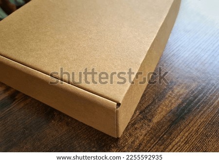 Brown carboard box mockup. Template of a carton packaging on wooden surface
