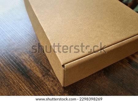 Brown carboard box mockup. Template of a carton packaging on wooden surface
