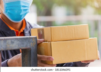 Brown Cardboard Box Was Holding By Delivery Man Wear Hygienic Mask By Dis-focused Style With Light Leak 