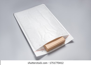 Brown cardboard box packed in white bubble envelopes on grey bac