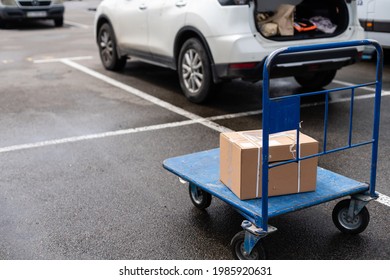 Brown cardboard moving box in the cart