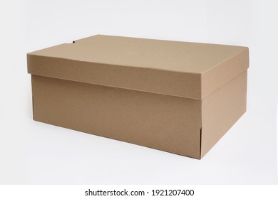 Brown cardboard shoes box with lid for shoe or sneaker product packaging mockup, isolated on white background with clipping path. Craft paper box. Front view. 