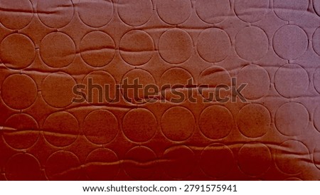 brown cardboard texture showcasing repeating circular sticker cutouts creates a minimalist geometric pattern