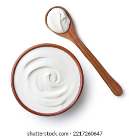 Brown ceramic bowl and wooden spoon of fresh sour cream isolated on white background, top view