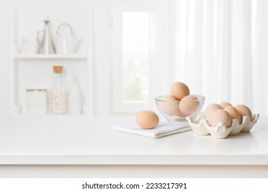 Brown chicken eggs in carton box on kitchen table interior - Powered by Shutterstock