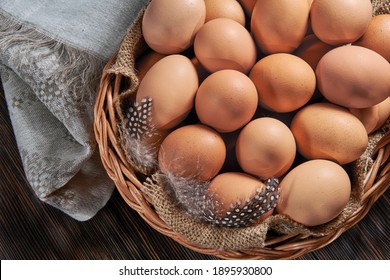 Brown chicken eggs close-up in a wicker wooden basket, organic protein of natural origin, free space for text. Rustic natural products.