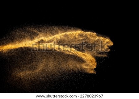 Brown colored sand splash.Dry river sand explosion isolated on black background.