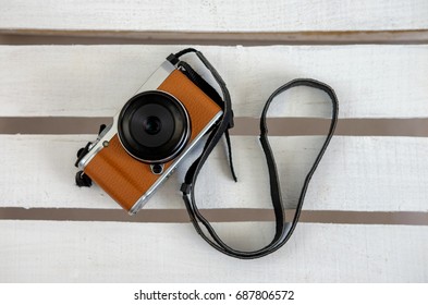 brown compact camera on white boards top view