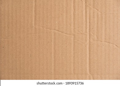 Brown Corrugated Cardboard Texture With Wrinkles And Creases. Carton Structure Of A Packaging Box Used For Shipping And Delivery. Damaged Parcel Material.