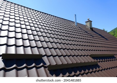   Brown corrugated metal profile roof installed on a modern house. The roof of corrugated sheet. Roofing of metal profile wavy shape. Modern roof made of metal. Metal roofing.                         