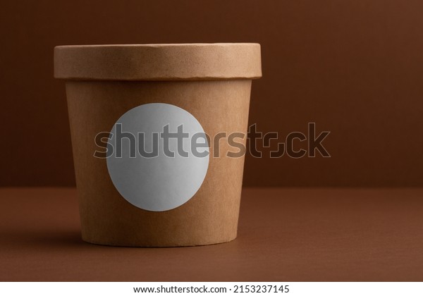 Brown crafted paper cup for soup on dark brown\
background with copy space. Eco package. Zero Waste. Mock up for\
branding.