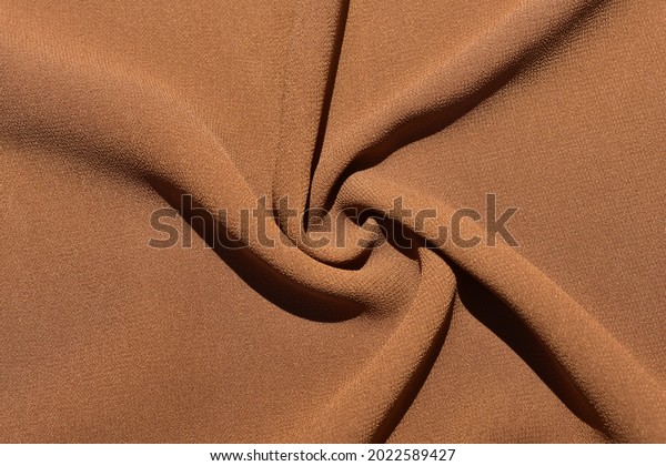 a brown\
crepe bubble cloth that has a texture like orange peel, and has a\
lightweight material, and easily follows the shape of the body.\
This material is often made into a\
hijab