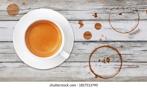 Brown Cup Full Of Espresso Coffee On Saucer, With Ring Coffee Stains And Drops On White Painted Wooden Table Background, Elevated Top View, Directly Above