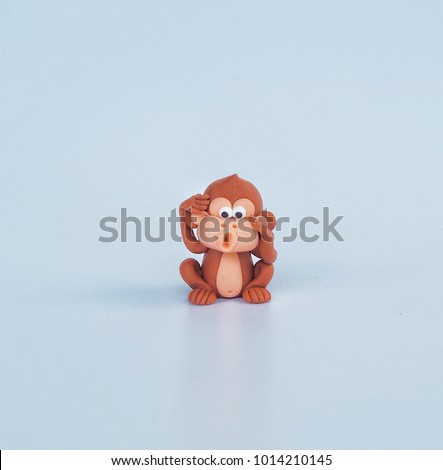 Brown cute cartoon monkey clay with naughty face on white background , plasticine for kid