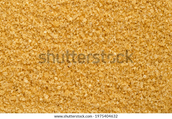 Brown demerara sugar, background, from above.\
Coarse, crystalline, natural and raw sugar, a sucrose sugar with\
distinctive yellow-brown color, due to presence of molasses.\
Backdrop. Macro, food\
photo.