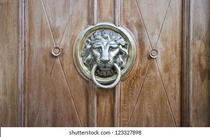 A brown door with beautiful bronze retro style carved lion head handle (knocker)