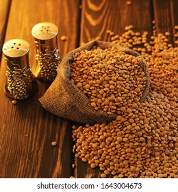 Brown Dried Lentils On A Wooden Table.Candle Light.
