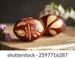 Brown Easter egg dyed with onion skins with spring flowers, closeup