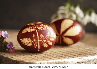 Brown Easter egg dyed with onion skins with spring flowers, closeup