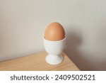 Brown eggs in eggcup on a wooden table