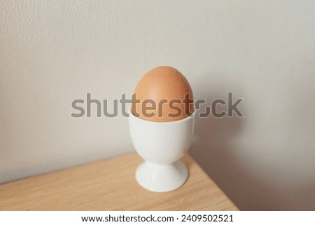Brown eggs in eggcup on a wooden table