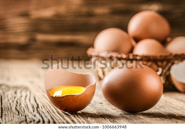 木のかごに茶色の卵 割れた卵の前に黄身を付けたもの の写真素材 今すぐ編集