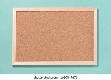 Brown empty corkboard for notes on a green background