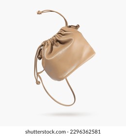 A brown female handbag with straps flying on a gray background. Minimalistic layout with bag. Advertising for ladies store, blog. Trendy women's accessories. Copy space. Objects for design, Mock up.