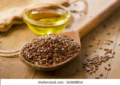 Brown Flax Seeds On A Spoon And Flaxseed Oil.