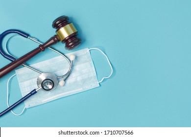 Brown Gavel And A Medical Stethoscope On Blue Background. Symbol Photo For Bungling And Medical Error