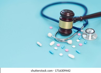 Brown Gavel And A Medical Stethoscope On Blue Background. Symbol Photo For Bungling And Medical Error