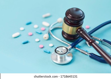 Brown Gavel And A Medical Stethoscope On Blue Background. Symbol Photo For Bungling And Medical Error