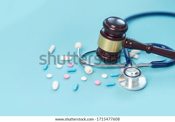 brown gavel and a medical
stethoscope on blue background. symbol photo for bungling and
medical error