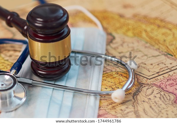 brown gavel and a
medical stethoscope and a protective mask on a geographical map.
symbol photo for bungling and medical error. Concept stay home and
remote work.