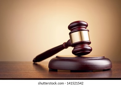 brown gavel on the table on a brown background