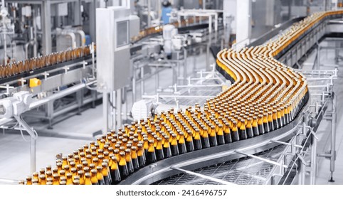 Brown glass beer bottles on conveyor belt Automated brewery industry manufacturing with sunlight. - Powered by Shutterstock