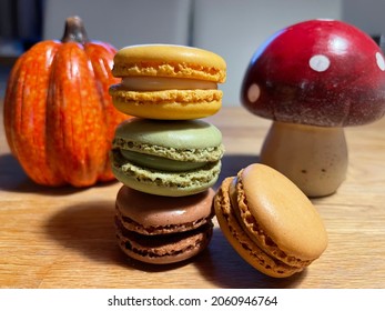 Brown Green And Yellow Macarons With Fall Decoration On Wooden Table