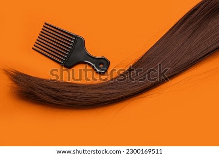Brown hair with brush on color background