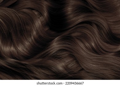 Brown hair close-up as a background. Women's long brown hair. Beautifully styled wavy shiny curls. Hair coloring. Hairdressing procedures, extension. - Shutterstock ID 2209436667