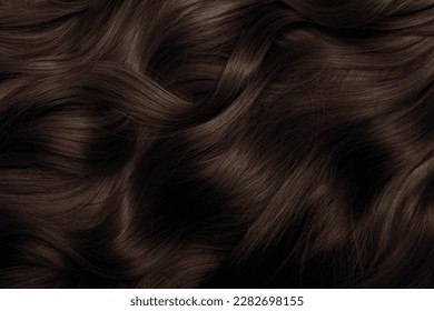 Brown hair close-up as a background. Women's long brown hair. Beautifully styled wavy shiny curls. Hair coloring. Hairdressing procedures, extension. - Shutterstock ID 2282698155