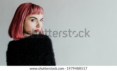 Brown hair woman in a black fluffy sweater looking back over her shoulder