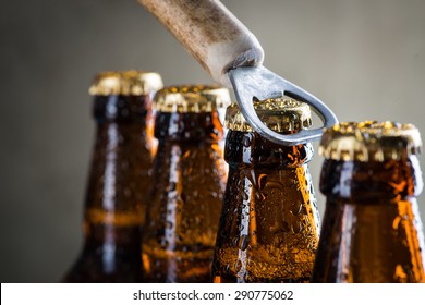 Brown ice cold beer bottles with water drops and old opener - Powered by Shutterstock