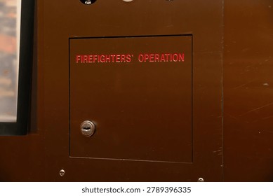 Brown industrial control panel featuring a red 