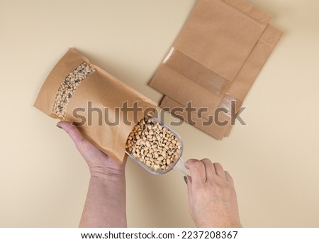 Brown kraft paper doypack bags with black-eyed peas on a yellow background. Packaging for foods and goods template mock-up. Packs with windows for weight products.Top view